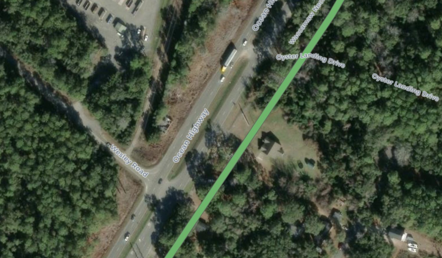 The East Coast Greenway mapping tool at Wesley Road and Ocean Highway. A thick green line marked Waccamaw Neck Bikeway runs well east of the highway, through the woods and the parcels beside it.